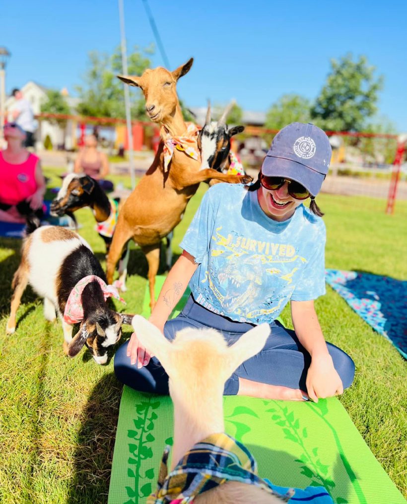 woman laughing during goat yoga