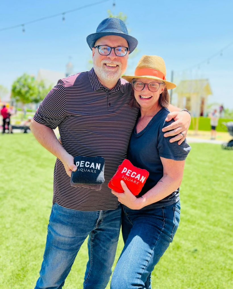 happy couple posing with Pecan Square swag